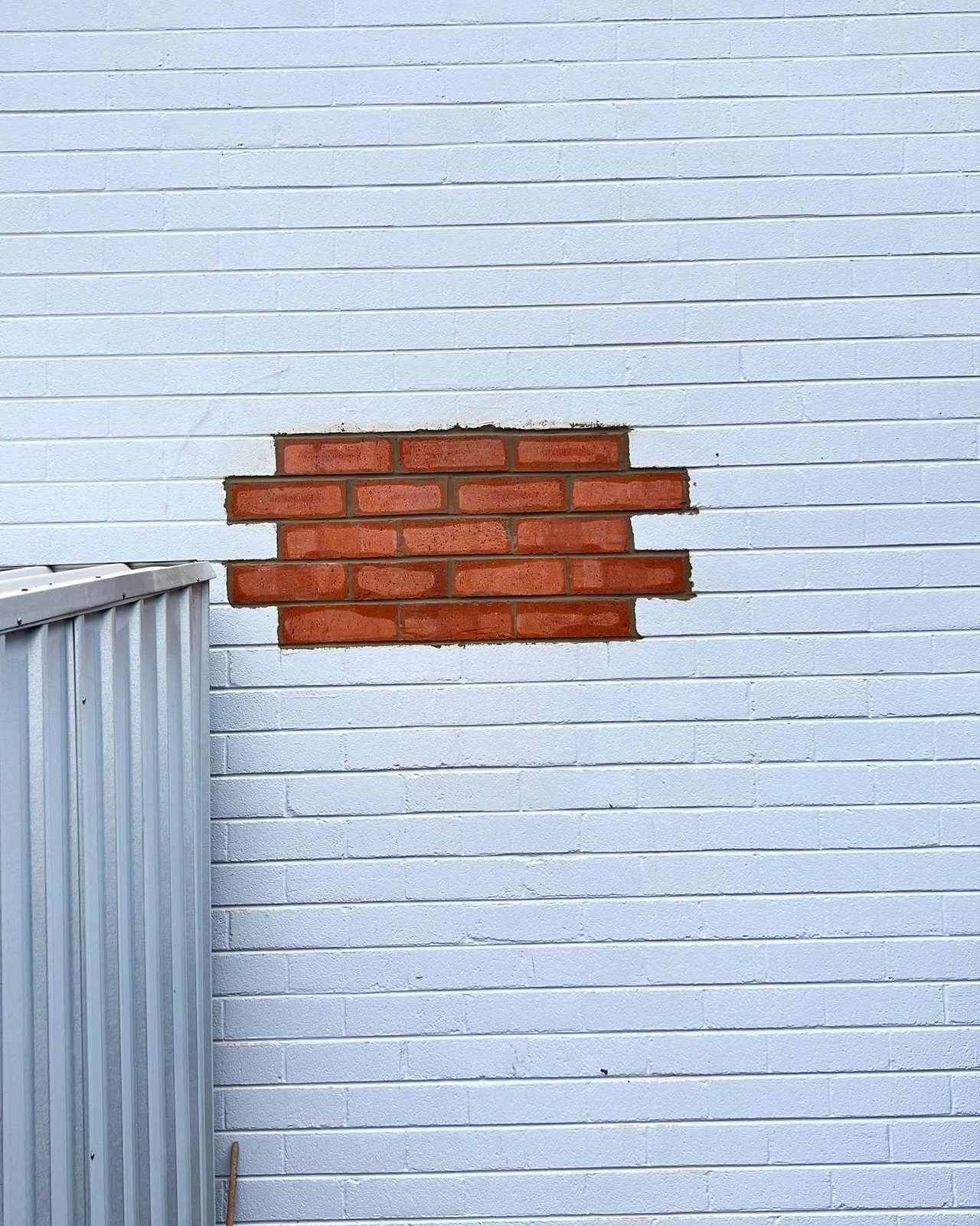 Brick patch repair in a weatherboard wall
